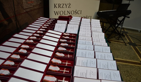 Krzyże Wolności i Solidarności ułożone na stole przed ceremonią dekoracji odznaczonych