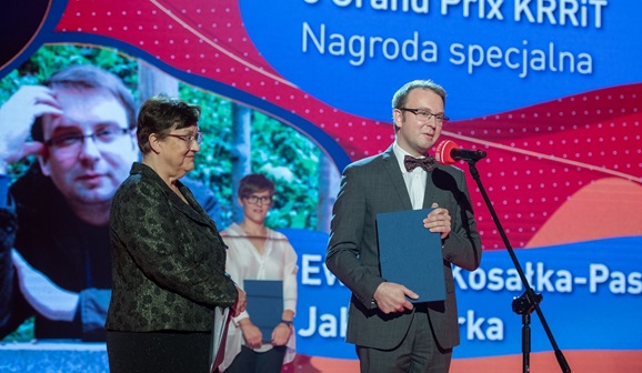 Jakub Tarka trzyma dyplom w granatowym etui i wygłasza przemówienie