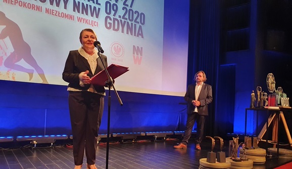 Członek KRRiT Elżbieta Więcławska-Sauk przemawia na tle ekranu z logo festiwalu
